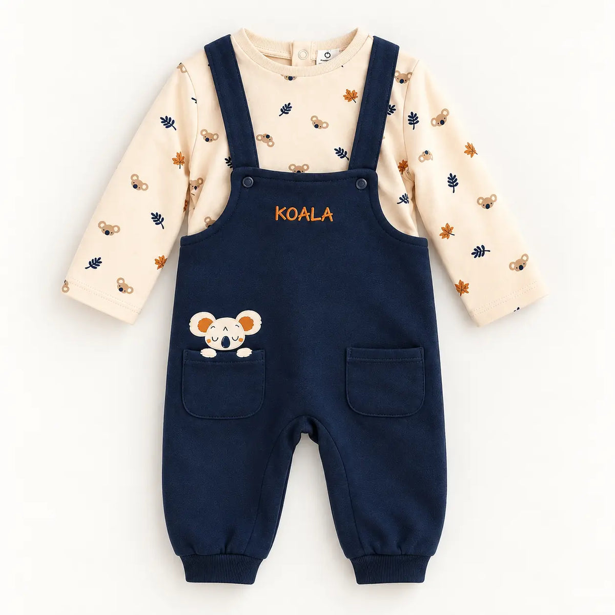 Jardineiras azul-marinho com bolsos e aplicação de koala, combinadas com camisola pérola de manga comprida com estampado de coalas e folhas.