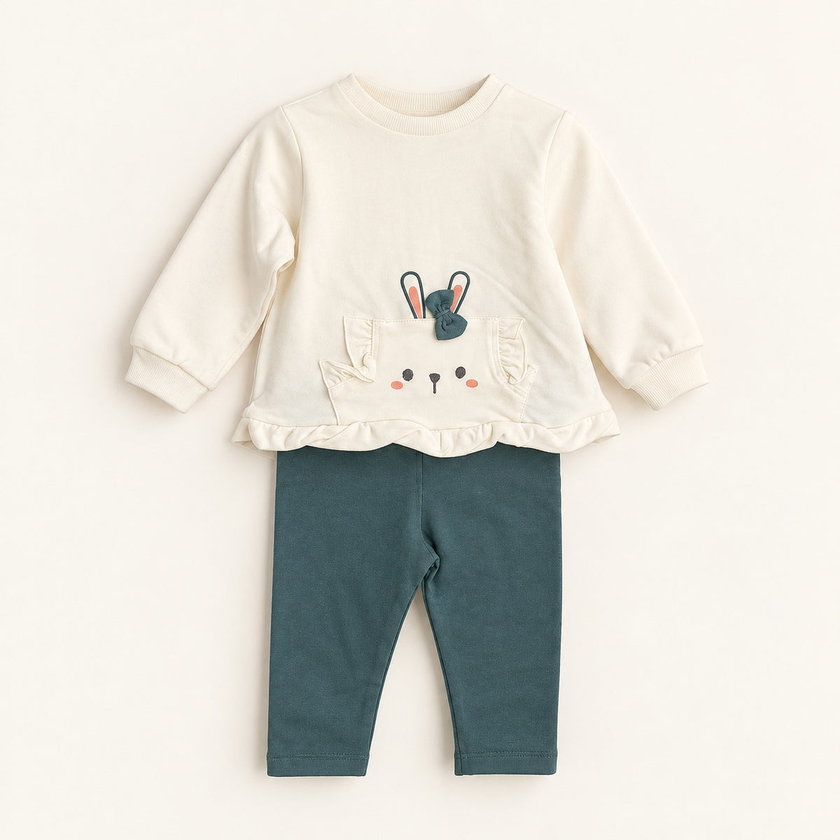Conjunto de bebé com camisola pérola de manga comprida, bolso decorado com cara de coelho, orelhas e laço verde, combinado com leggings verde-escuro.