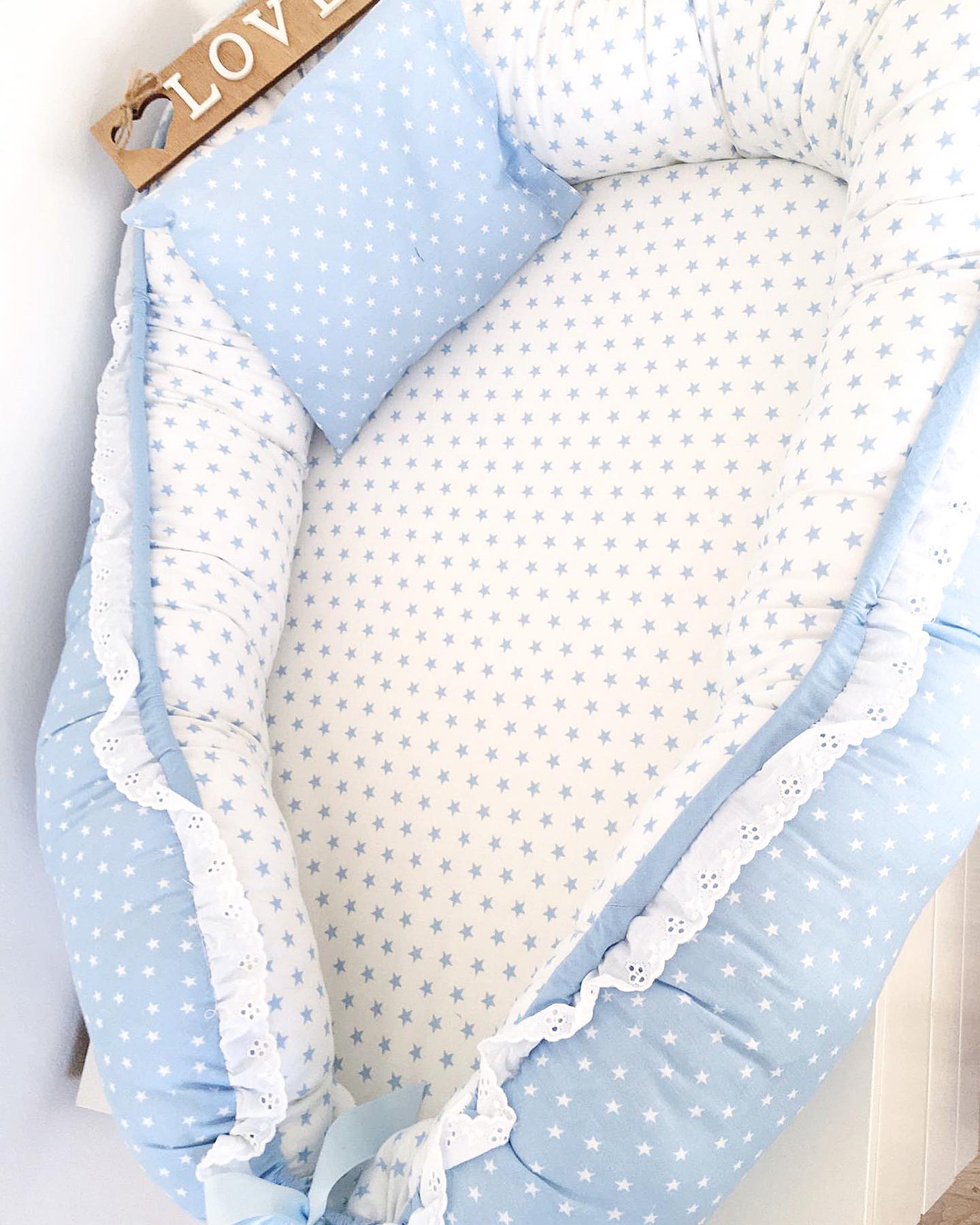 Ninho para bebé com estrelinhas e detalhe de renda azul
