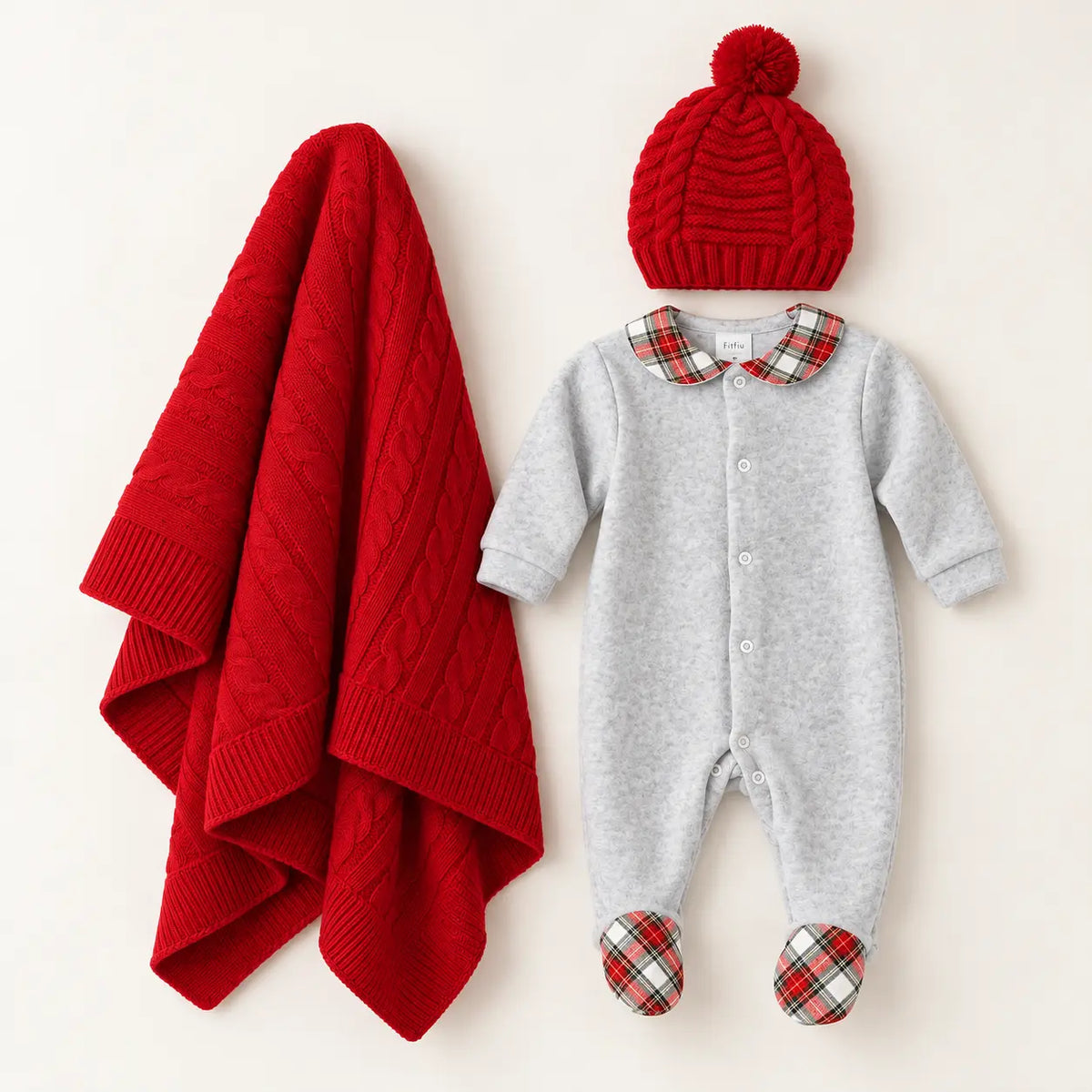 Pack de bebé com babygrow de veludo cinza e gola xadrez, manta de malha vermelha e gorro vermelho com pompom