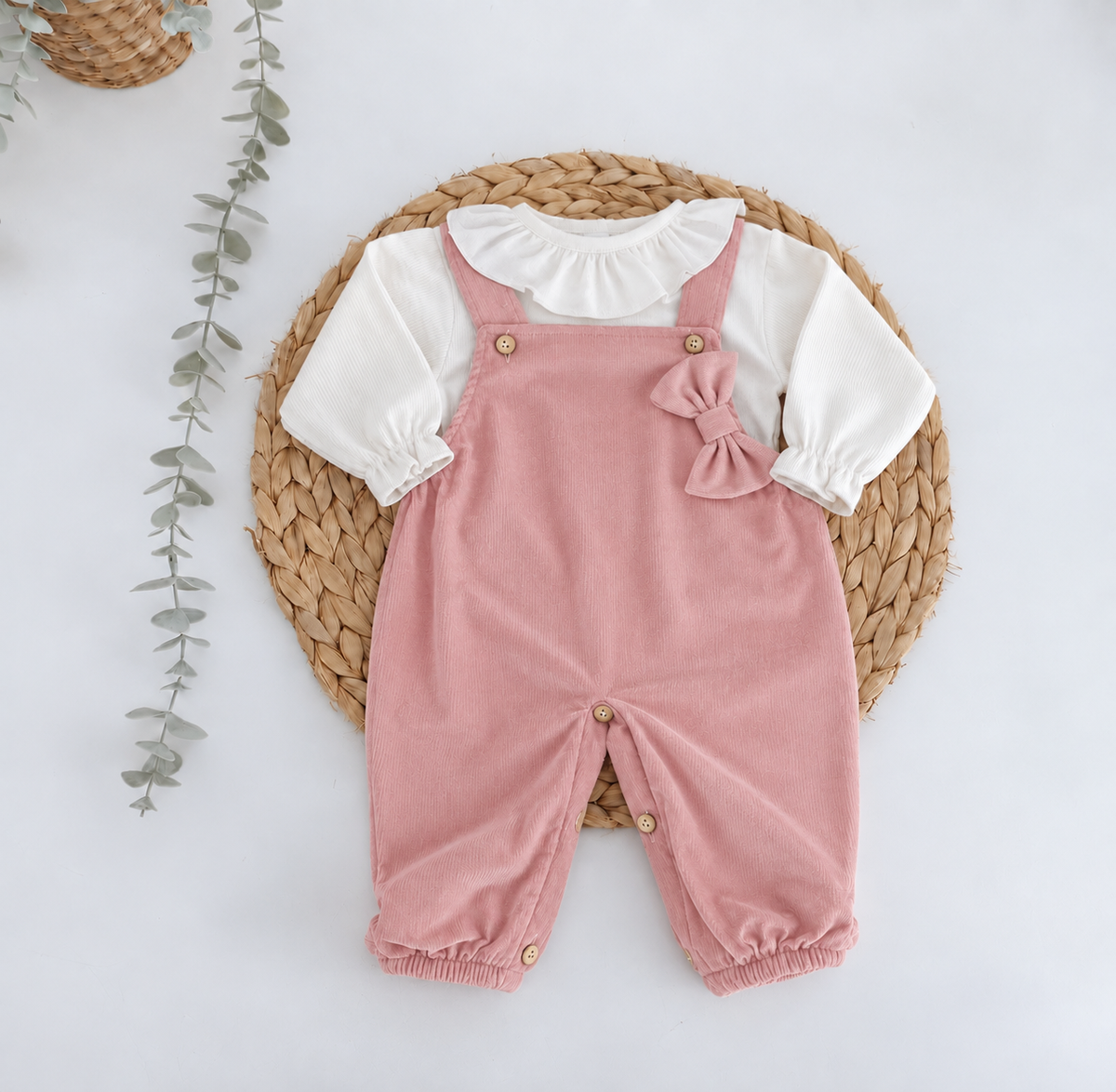 Jardineiras rosa velho de bombazine para bebé com blusa branca e laço
