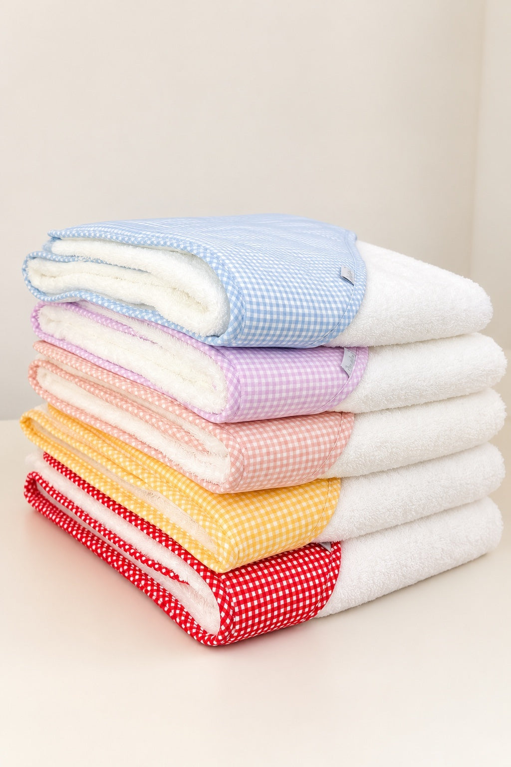 Toalhas de banho brancas para bebé com capuz e acabamento em padrão vichy azul, lilás, vermelho, amarelo e rosa.