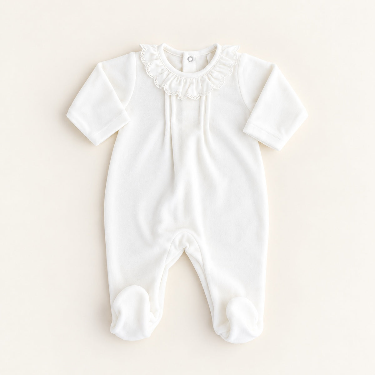 Babygrow de veludo pérola para bebé, com gola franzida de bordado inglês, mangas compridas e pés integrados.