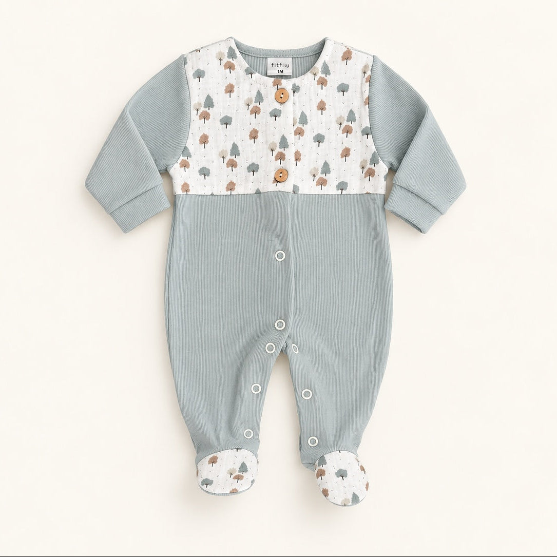 Babygrow FitFiu Babies® verde suave em algodão, com peitilho estampado de pequenas árvores, botões decorativos em madeira e detalhes a combinar nos pés.